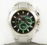Relógio Technos cronógrafo 0520-HJ, caixa 48mm e pulseira em aço, mostrador negro com detalhes em verde, máquina sem funcionamento.