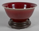 Bowl em porcelana chinesa sangue de boi, acompanha peanha em madeira entalhada, medindo: altura 12 cm, diâmetro 26 cm