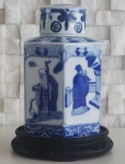 Garrafa sextavada em porcelana chinesa azul e branca, decorada com figuras de Sábios, altura 22 cm, acompanha peanha de madeira, com um lascado.OBS: RETIRADA NO LOCAL AV ATLANTICA.