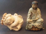 Lote com 2 esculturas, sendo uma porcelana oriental representando Buda, 25 cm de altura, e uma escultura em barro representando Santo, medindo 15x20x14 cm. OBS: RETIRADA NO LOCAL AV ATLANTICA