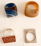 4 anéis em diversos materiais, c/ pedra ágata azul aro 15, c/ ágata laranja aro 25, c/ cloisone e espiral aro 20,5 e em metal quadrado aro 13