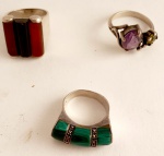3 anéis em diversos materiais, c/ pedra preta e vermelha aro 14, c/ pedra ametista aro 16 e c/ pedra verde aro 12 (c/ contraste de prata)