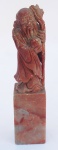 Grupo Escultórico em pedra dura chinesa representando Velho Sábio com cajado e frutos, com marcas do tempo, medindo 11 cm de altura.