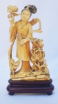 Grupo Escultórico Oriental, representando  Gueixa no Jardim do Paraíso, assinado, acompanha peanha de madeira, medindo 20 cm de altura.