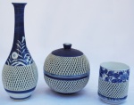 Conjunto de Porcelana azul e branca, ricamente trabalhada e fenestrada, sendo todas assinadas, medindo vaso: 24 cm de altura; bowl: 14 cm de altura com tampa; copo: 9cm de altura.