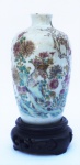 Vaso em formato Balaustre, em porcelana chinesa, decoração família rosa, selo vermelho, acompanha peanha em madeira nobre entalhada, altura do vaso 14 cm, altura com a peanha 17 cm.