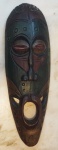 Máscara africana esculpida com policromia ,medindo 49 x 16 cm.