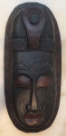 Máscara africana esculpida com pintura em policromia, medindo 40 x 18 cm.
