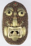 ARTE AFRICANA. Máscara em madeira revestida de metal,latão, pedra vermelha e olhos em vidro, medindo 29 x 17 x 10 cm.