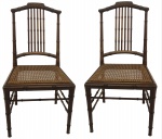 Par de cadeiras em  madeira entalhada imitando cana da India, assentos em palhinha. Acompanham almofadas .NO ESTADO. Medidas 85 x 50 x 48 cm.