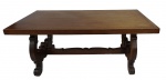 Mesa para jantar rústica em madeira nobre, tampo sustentado por 2 pés com travessão e travas, tampo protegido por vidro. Medidas 76 x 180 x 90 cm. No estado.