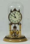 Relógio de mesa em metal dourado, redoma de vidro, procedência Alemã, (falta chave), não testado. Medidas, altura 31 cm e diâmetro 18 cm.