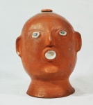 Arte popular brasileira - Diferente garrafa em barro pintado representando cabeça masculina, sem assinatura, (no estado).Medidas, altura 24 cm e diâmetro 17 cm.