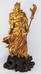Escultura oriental em madeira entalhada, policromada em dourado, representando samurai, apoiada por base de madeira patinada, altura total 88 cm