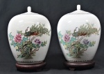 Par de vasos com tampa em porcelana oriental, decorado com faisão e flores, acompanha peanha de madeira, marca na base, selo vermelho. Alturas 30 cm.