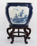 Aquário de porcelana chinesa azul e branco, decorado com cena do cotidiano com gueixas, acompanha peanha. Medidas 50  x 51 cm.  Total 70 cm.
