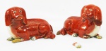 Par de cães Cia. Das Indias em porcelana Rouge fer, sendo 1 com pé quebrado (pedaço anexo). Medidas, 16x15x24 cm.