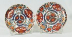 Par de pratos em porcelana japonesa Imari, ricamente trabalhado, em tons de azul, , rouge de fer, verde e ouro, com 24 cm de diâmetro ( pequeno bicado em cada prato)