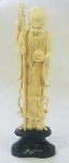 Estatueta em marfim esculpido, representando Ancião, acompanha peanha em madeira trabalhada, altura 24 cm