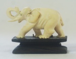 Escultura em marfim, representando Elefante (1 presa quebrada) acompanha peanha em madeira, medindo 5x6 cm