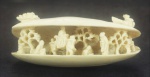 Estatueta em marfim, em forma de concha c/ figuras no interior, medindo 3x6 cm