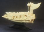 Barco esculpido em marfim c/ figuras, acompanha peanha em madeira, medindo 8x13 cm