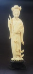 Estatueta em marfim, representando Gueixa, acompanha peanha em madeira, medindo 13 cm