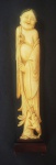 Estatueta representando ancião com animal, cabelo policromado, acompanha peanha em madeira, medindo 26cm.