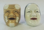 Conjunto de saleiro e pimenteiro em porcelana japonesa, representando máscaras kabuk, medindo 5 cm cada