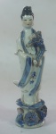 Estatueta em porcelana chinesa,  representando figura de Gueixa c/ flor de lótus, medindo 20 cm