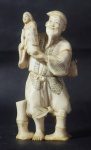 Grupo escultórico em marfim representando velho sábio camponês segurando criança nos braços. Medida: 11 cm.