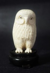 Pequena escultura em marfim chinês representando coruja. Base em madeira. Medida: 7cm.