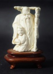 Pequena escultura em marfim chinês representando velho sábio com jovem. Base em madeira. Medida: 7cm.