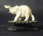 Pequena escultura representando elefante. Base em madeira. Medida: 5x5cm.