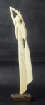 Escultura em marfim africano representando figura feminina. Base em madeira. Medida: 20cm.