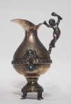 Ânfora/jarra em metal expessurado prata, pega com figura de menino. Aplicações em pedra azul turquesa. Medida: 13x8x7cm.