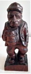 Escultura em madeira entalhada representando figura com caneca. Medida: 20cm.