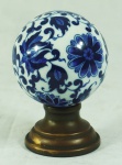 Esfera em porcelana chinesa azul e branca, base em bronze. Medida: 12cm de altura.