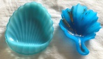 Duas saboneteiras em opalina azul: uma em forma de concha medindo 14x11cm e outra em formato de folha medindo 13 x10 cm.