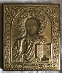 Ícone em metal dourado decorado com flores e inscrições com figura de cristo sobre madeira medindo 18 x15,5 cm.