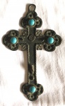 Crucifixo em metal com quatro pedras azuis, parte trazeira cinzelada, medindo 41x7cm. Falta o Cristo.