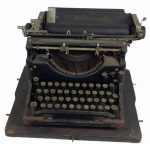 Máquina de escrever da marca "UNDERWOOD" sobre painel de madeira , com tampa de metal. Medidas 26 x 38 x 34 cm.