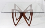 VLADIMIR KAGAN (1927/2016) - VK. Estilosa mesa de jantar no modelo borboleta, com estrutura em madeira nobre Cumarú, tampo em vidro liso incolor de 10mm, medindo 140x140cm. Comporta 8 lugares.