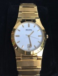 Relógio de pulso masculino, marca: Bulova, caixa 35 mm, caixa e pulseira em metal dourado, fundo branco, acompanha estojo original, elos sobressalentes da pulseira para ajuste.