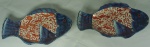 Par de covilhetes no formato de peixe em porcelana japonesa Imari, ricamente decorados em tons de azul cobalto e rouge de fer, medindo 26x17cm cada.