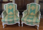 Par de imponentes poltronas no estilo Luís XVI com pátina provençal, estofadas em tecido estampado predominantemente verde, medindo 90x75x80cm cada.