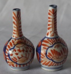 Par de miniatura de vasos no formato de bilha em porcelana japonesa Imari nas cores azul cobalto, rouge de fer, medindo 8cm de altura cada.