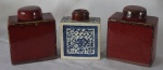 Três caixas para chá em porcelana chinesa, sendo uma decorada nas cores azul e branca medindo 14x11x5cm e as outras duas na cor sangue de boi medindo 16x12x7cm (tampa quebrada, caixa colada, faltando 1 peça).
