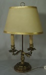 Abajour para duas lâmpadas tendo em seu corpo castiçal no estilo francês em metal dourado e cúpula única em pergaminho. Medida total: 47cm.