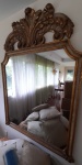 Grande espelho estilo barroco em madeira policromada, encimado por grande florão, (espelho marcas do tempo). Medida 1,64 x 1,24 cm.